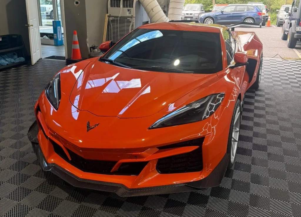 Orange Chevrolet Corvette C8 with glossy ceramic coating finish in the shop bay