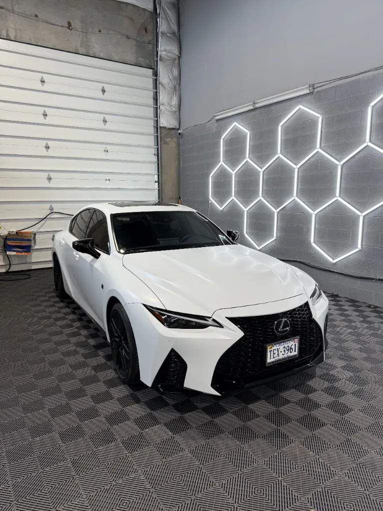 White Lexus sedan with black accents and window tint after PPF work in the shop