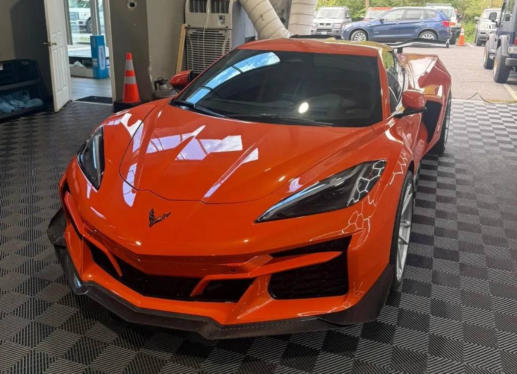 Orange Chevrolet Corvette C8 with glossy ceramic coating finish in the shop bay
