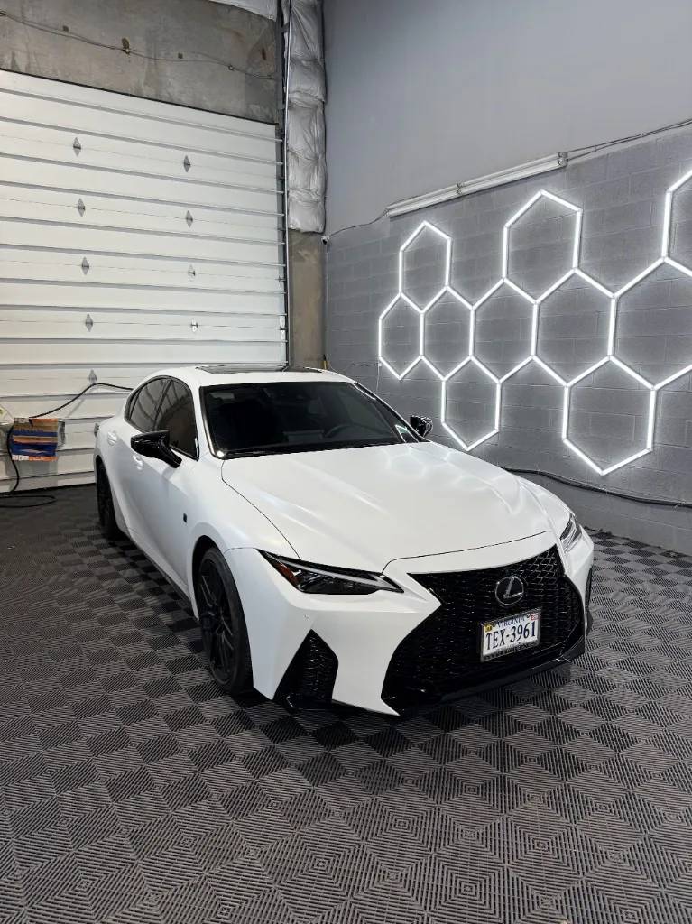 White Lexus sedan with black accents and window tint after PPF work in the shop
