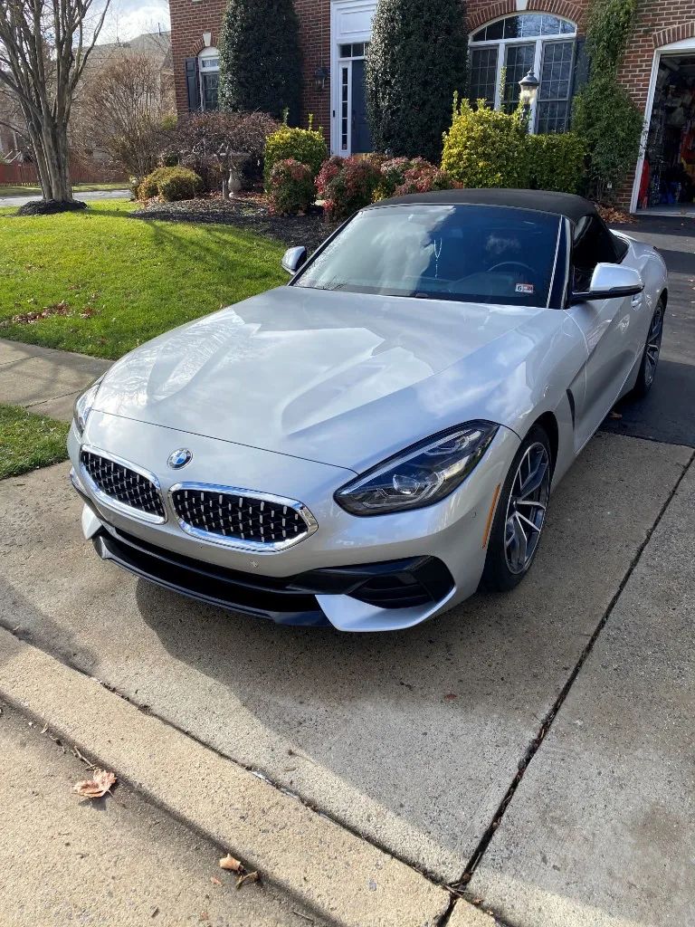 Silver BMW Z4 convertible with glossy ceramic coating finish on a residential driveway