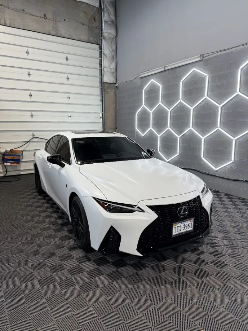 White Lexus sedan with black accents and window tint after PPF work in the shop