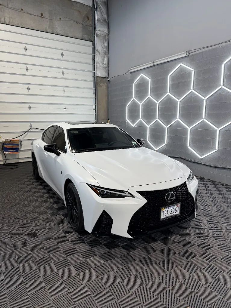 White Lexus sedan with black accents and window tint after PPF work in the shop